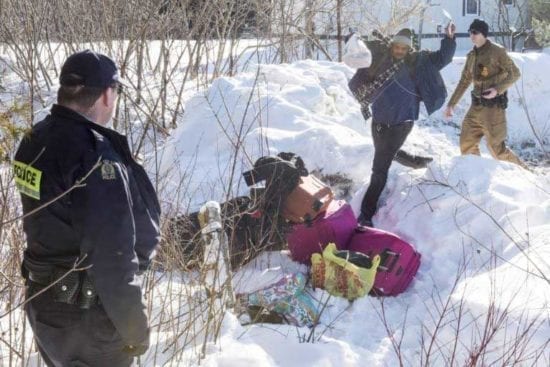 asylum seekers crossing the border into Canada, border guard watching