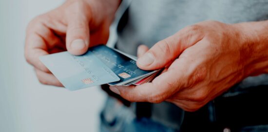 Closeup of a person's hands holding multiple credit cards